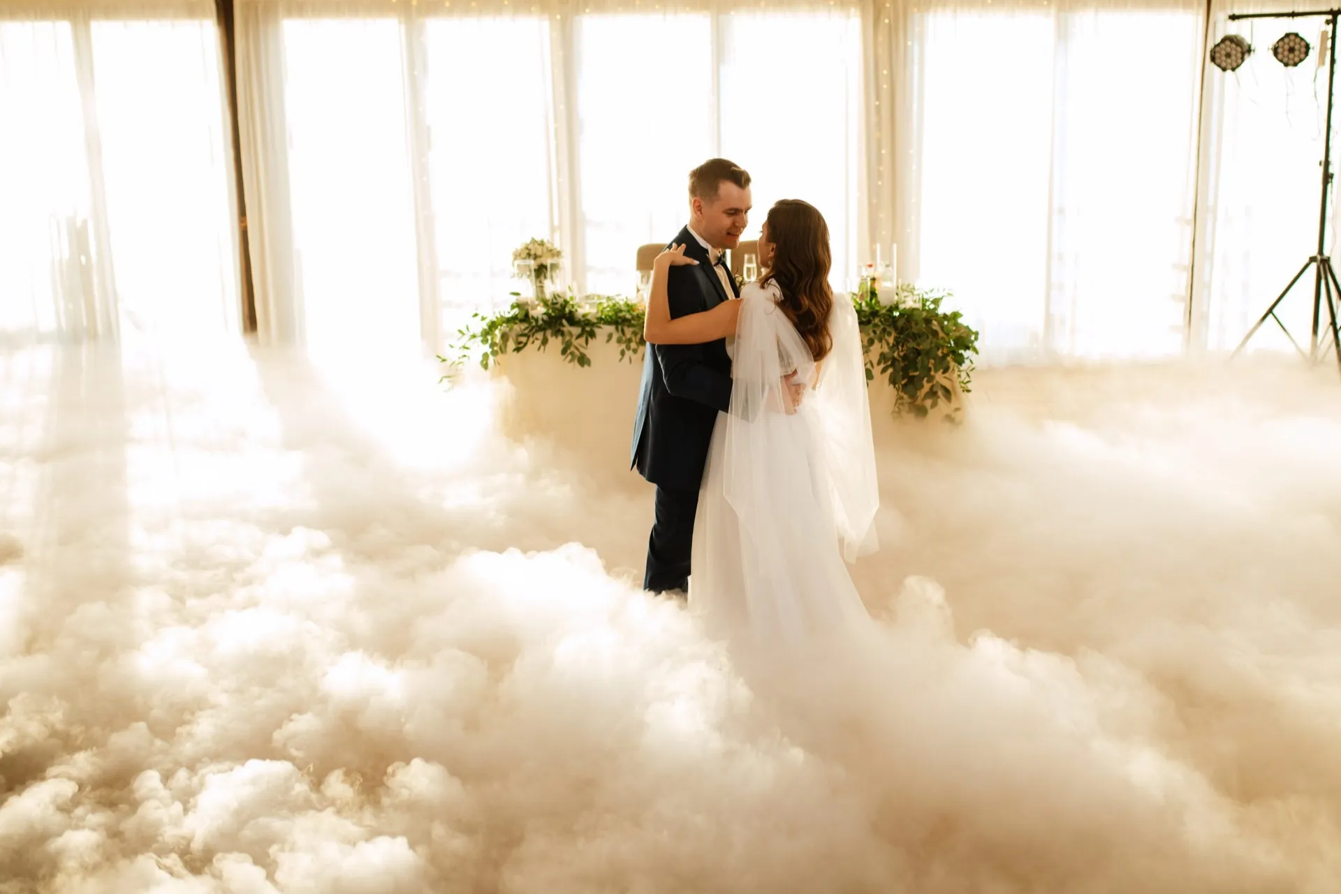 Bride and groom performing their wedding first dance amid clouds of low-lying fog